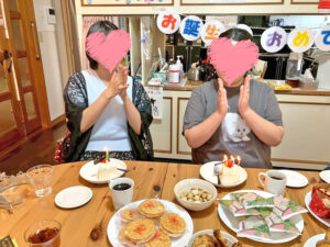 それぞれのケーキに立てられたキャンドルの前で、2人が歌に合わせて拍手をしている様子。テーブルにはお菓子や飲み物も並んでいる。